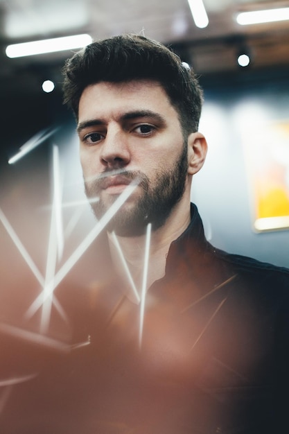 portrait of young man amidst illuminated lights