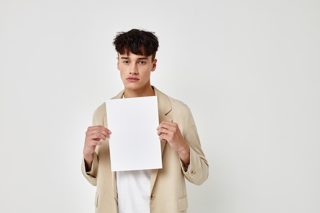 Portrait of a young man in a beige suit copyspace notebook light background unaltered