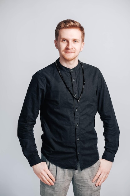 Portrait of a young man in a black shirt on a white background. Copy, empty space for text