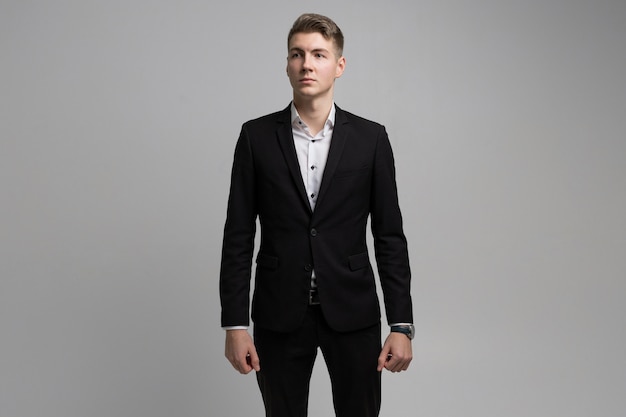 Portrait of young man in black suit