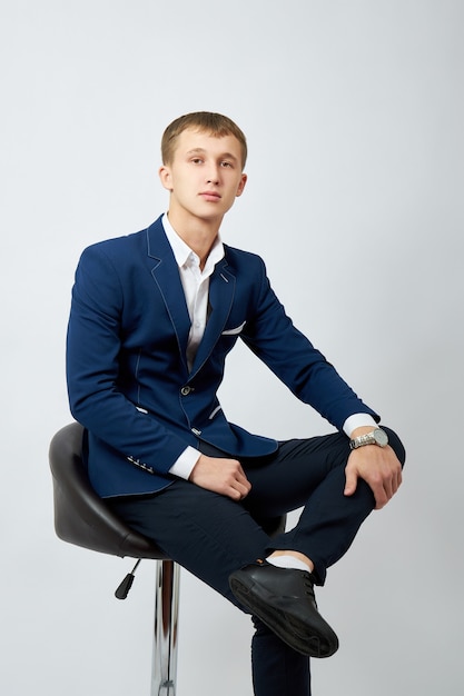 Portrait of a young man in a blue jacket on white