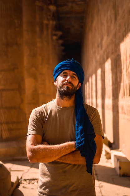 Portrait of a young man in a blue turban visiting the Edfu Temple near the city of Aswan. Egypt