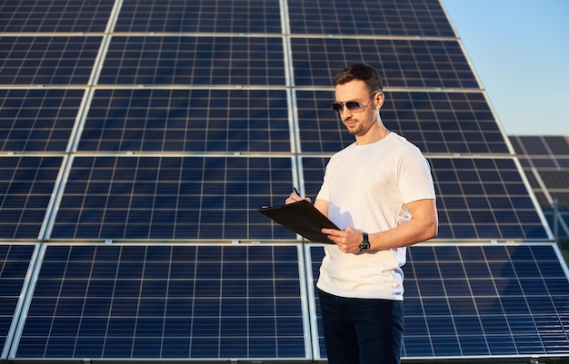 Portrait of a young man by solar panels