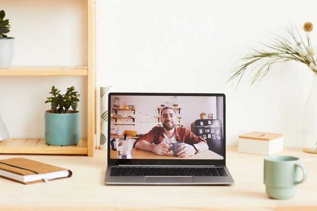 Portrait of young man in computer monitor smiling he has online conversation