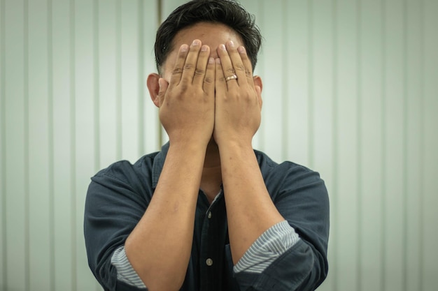 Portrait of a young man covering face