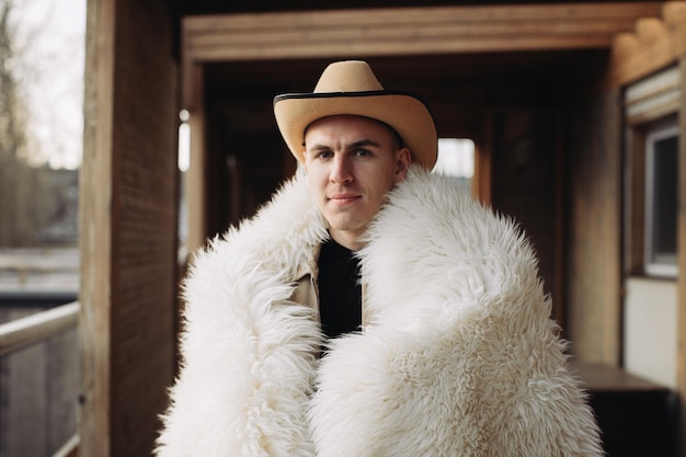 Портрет молодого человека, одетого в меха, на ранчо зимой