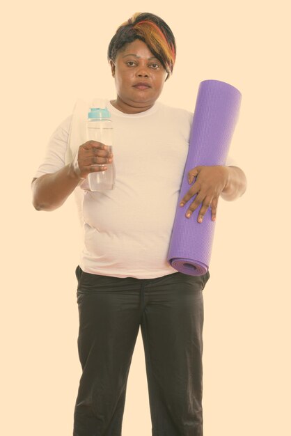 Portrait of young man drinking glass against white background