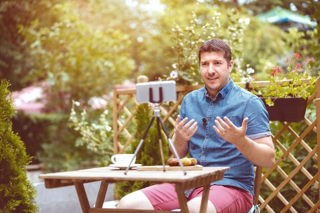 Portrait of young man drinking glass on table