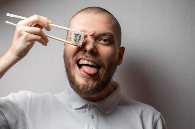 Portrait of a young man eating sushi