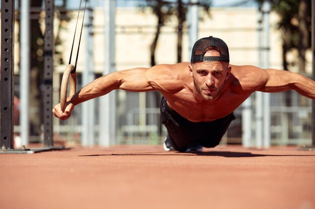 Photo portrait of young man exercising in gym