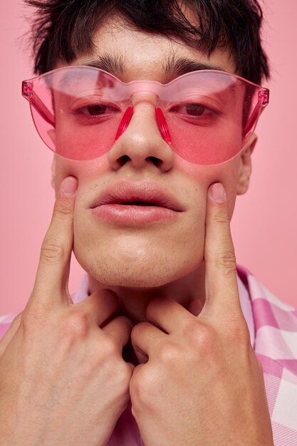 Portrait of a young man fashionable pink sunglasses jacket posing pink background unaltered