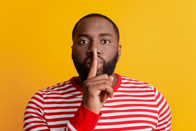 portrait of young man finger lips show silence sign