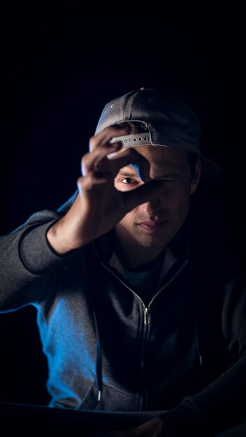 Portrait of young man gesturing against black background