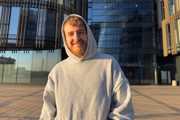 Portrait of young man happy university or college student smile outdoors at campus in hood