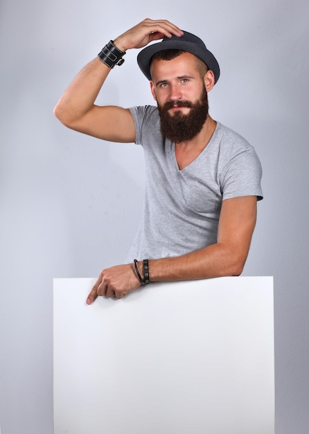 Portrait of young man in hat standing near blank isolated on white background