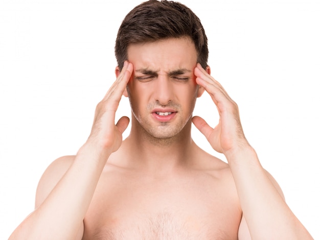 Portrait of young man having awful headache.