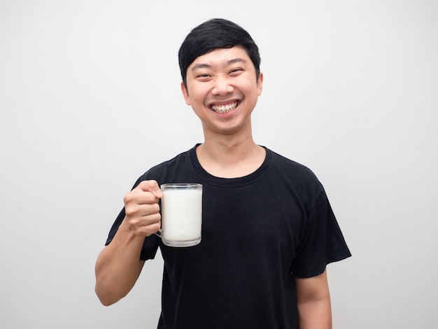 Портрет молодого человека здорового, держащего стакан молока счастливой улыбки