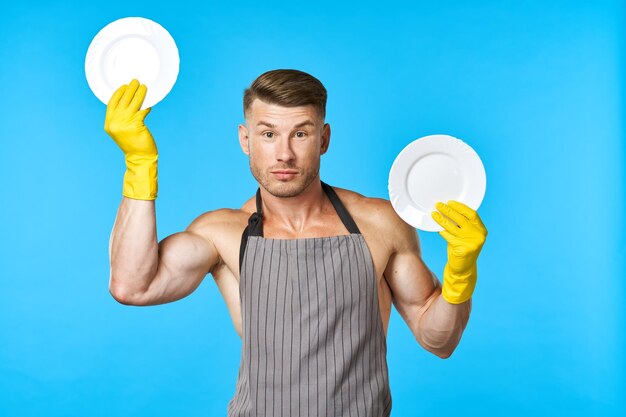 Portrait of young man holding balloons against blue background