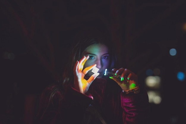 portrait of young man holding camera at night