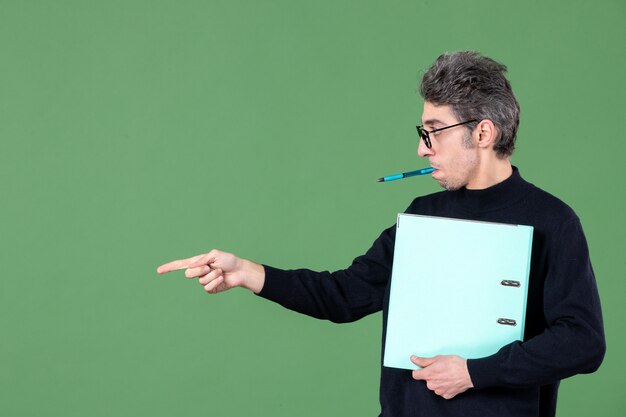 portrait of young man holding documents studio shot on green background lesson teacher business