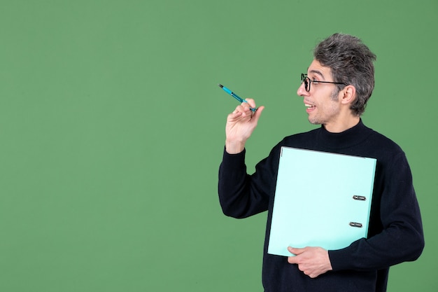 portrait of young man holding documents studio shot on green background teacher business lessons job