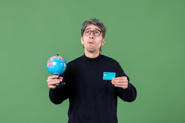 portrait of young man holding earth globe and credit card green background nature bank teacher male