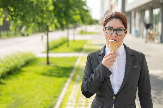 Portrait of young man holding ice cream standing outdoors