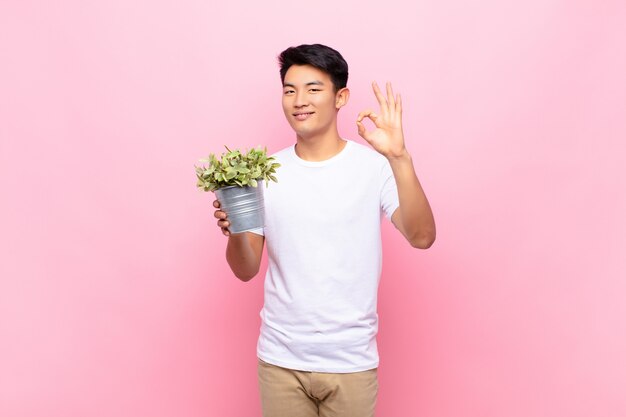 Portrait of a young man holding a plant