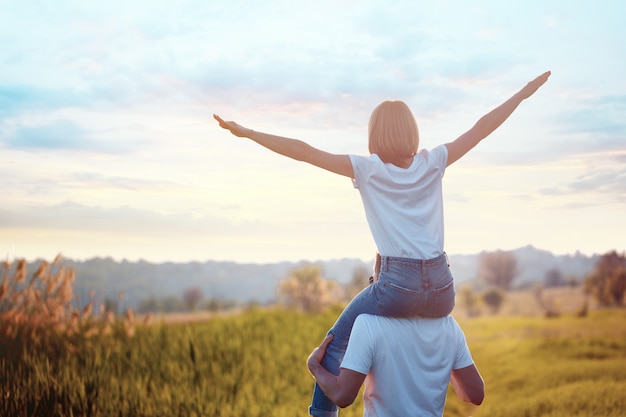 Portrait of young man holding on shoulders his happy girlfriend