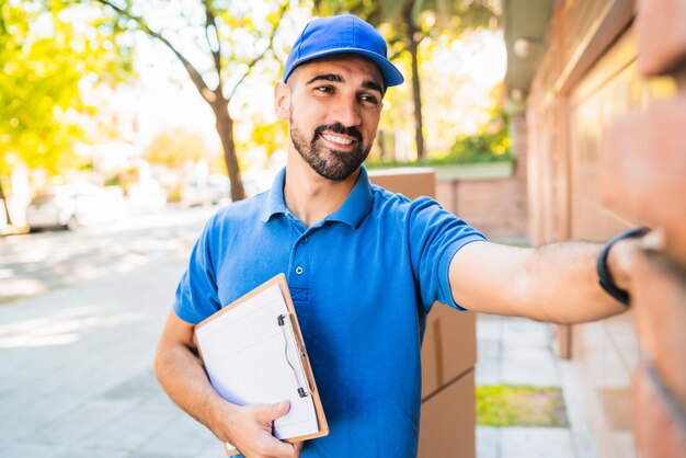 Portrait of young man holding smiling while standing in city