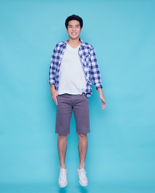 Portrait of young man jumping on blue