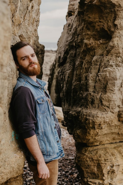 Photo portrait of young man leaning on rock formation