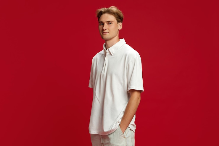 Photo portrait of young man in light clothes white shirt standing with little smile and looking at camera