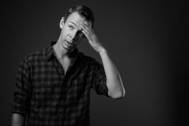 Photo portrait of young man looking away against black background