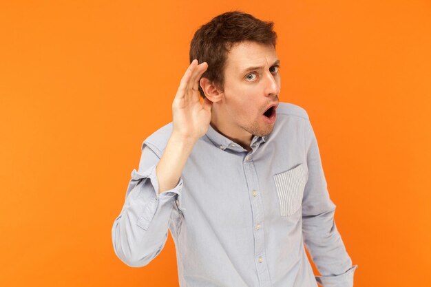 Photo portrait of young man looking away against orange background