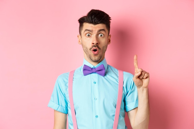 Portrait of young man looking away against pink background