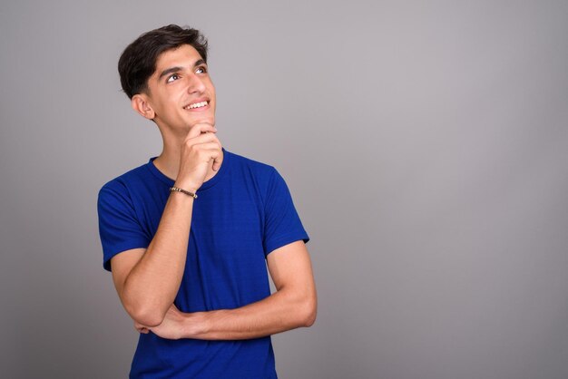 Portrait of young man looking away against white background