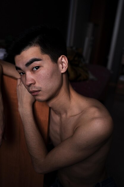 Photo portrait of young man looking away at home