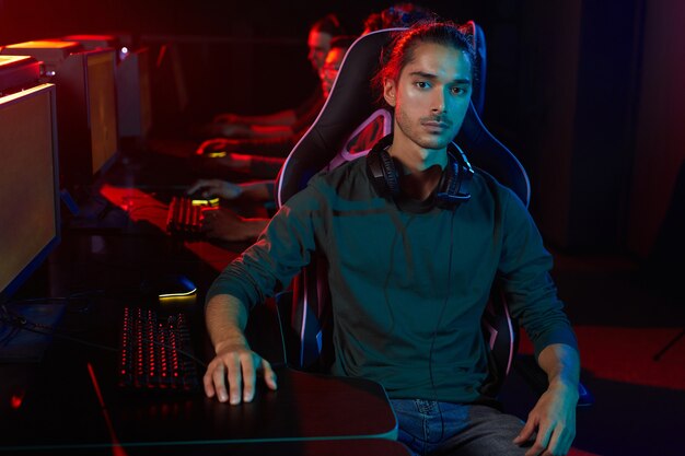 Portrait of young man looking at camera during his play in computer club