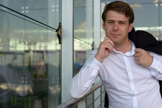 Portrait of young man looking through window