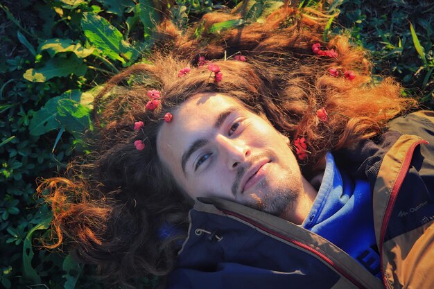 Photo portrait of young man lying on field