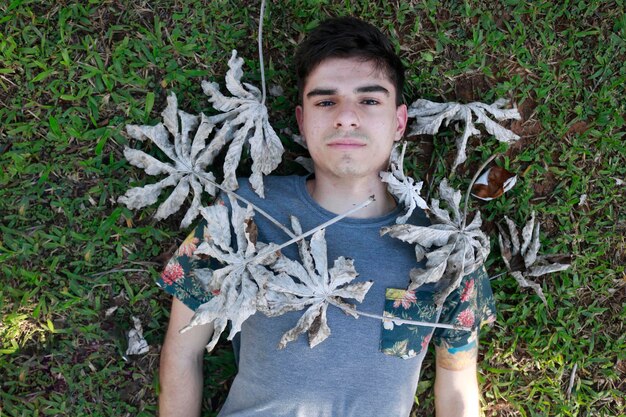 Photo portrait of young man lying on grassy field