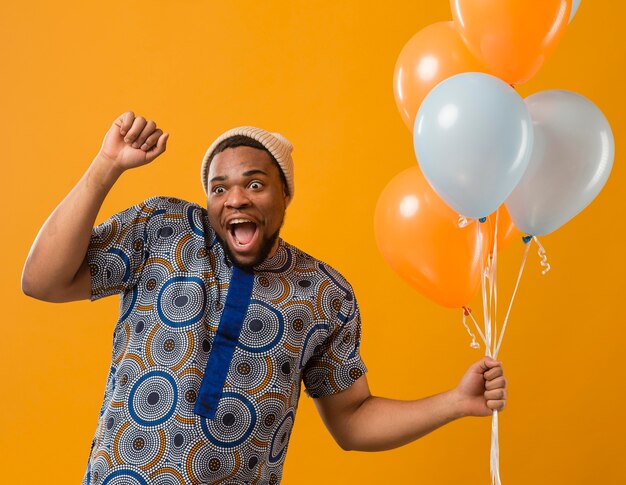 Portrait young man at party with balloons