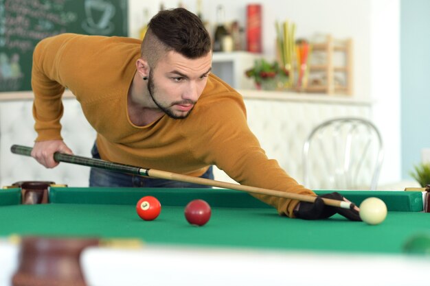 Photo portrait of a young man playing billiard, close up