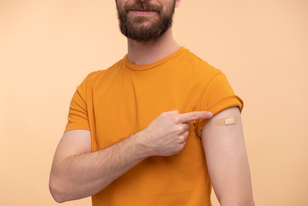 Portrait of young man pointing at his vaccine sticker