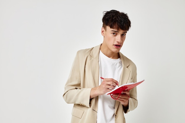 Portrait of a young man posing with a notepad in a suit isolated background unaltered