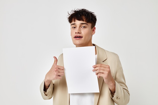 Portrait of a young man posing with a white sheet of paper isolated background unaltered