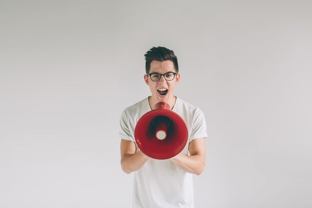 Portrait of young man shouting using megaphone