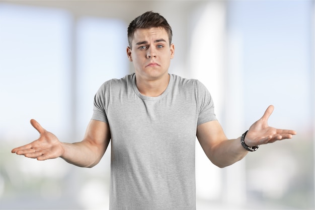 Portrait young man shrugging shoulders