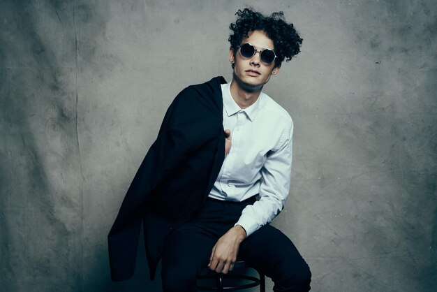 Portrait of young man sitting against wall